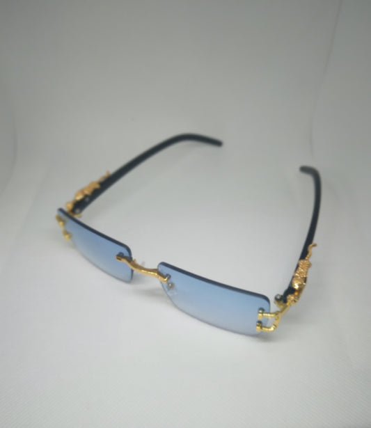 A pair of rimless, blue lens fashion glasses with gold accents on the hinges.